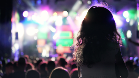 Silhouette girl with courly hair sitting on shoulder enjoying At Outdoor Music Festival Public concert, no ticketing eventの写真素材
