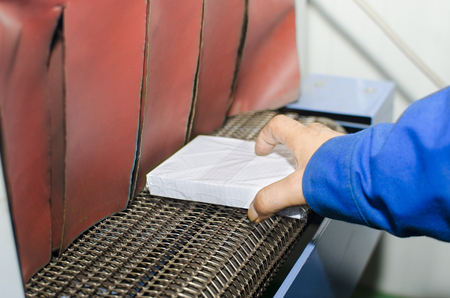 Operator hand place Book on Print plant roller conveyor, selective focusの写真素材