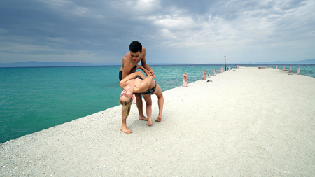 Happy romantic couple dance on beach pier smilingの写真素材