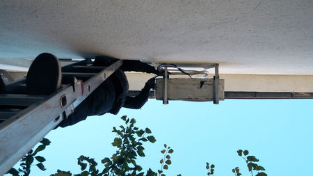 Technician repairing air conditioner on the wallの写真素材