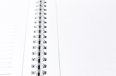 Close-up of a stack of spiral notebook / report / book over white background, selective focusの写真素材