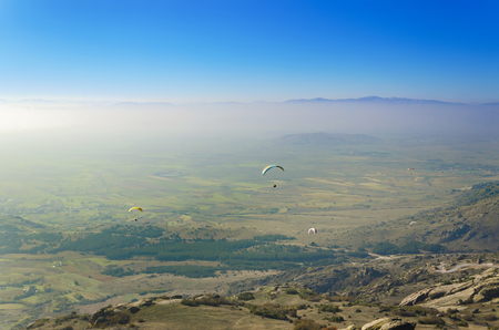 A lot of paragliders above misty foggy valleyの写真素材