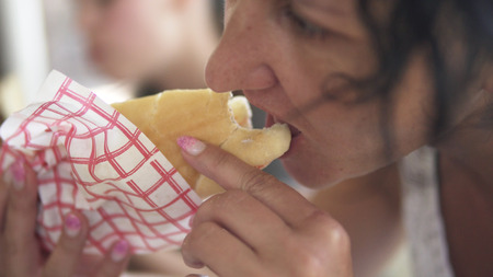 Young woman is eating doner kebab at lunch bites a delicious juicy shawarma. Fast food conceptの写真素材