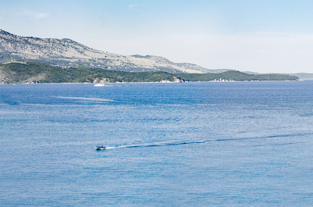 Aerial panorama of Greece Corfu, view of sea with sun reflecting on seawater and boat passing byの写真素材