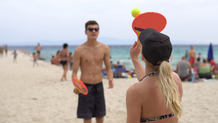 Couple in bikini playing beach-tennis, cinematic viewの写真素材