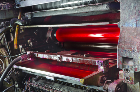 print machine printing press rollers, red magenda color drum, dramatic lightの写真素材