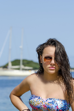 Boat woman looking at the camera sailing by. Hispanic / Caucasian female model, verticalの写真素材