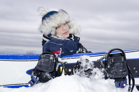 Happy snow boarder funny boy portrait wearing hat and scarf in december season looking at cameraの写真素材
