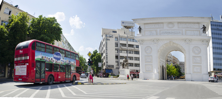 SKOPJE, MACEDONIA, circa FEBRUARY, 2016: Panorama of Macedonian gate in Skopje with red double decker bus public transportation. One of the many monuments built during skopje 2014 project.のeditorial素材