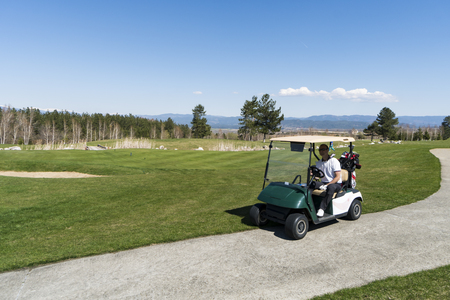 Friends driving golf cart in country club during summer holidayのeditorial素材
