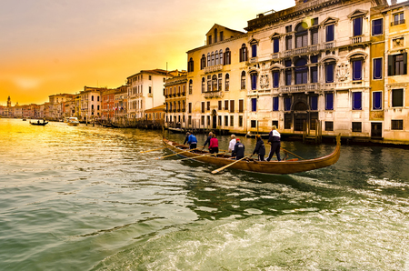 VENICE, ITALY - circa MARCH, 2016: Eight sportsmen rowing a sport gondola in Venice Canal Grande at sunset. Venice is situated across a group of 117 small islands that are separated by canals and linked by bridgesのeditorial素材