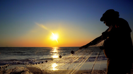 Sunset fishermans pulling net catching fish on ocean, cinematic steadicam shotのeditorial素材