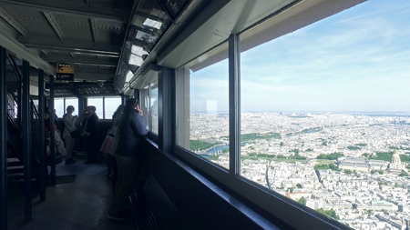 Tourist looking at the city from Eiffel tower top indoor unit. Tourist looking at the city of Paris from Eiffel tower top at dayのeditorial素材