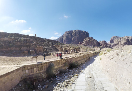 Camels and tourists walk through surreal desert landscape in old city of Petra in Jordan, panoramaのeditorial素材