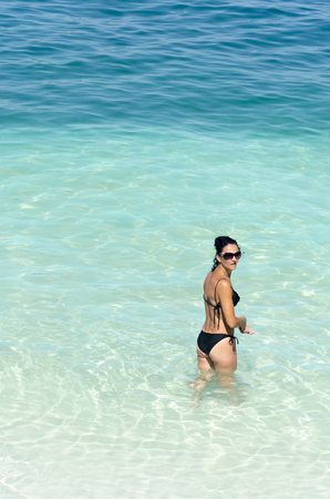 Beautiful woman's body in sexy bikini enjoy amazing clear sea water wild beachの写真素材