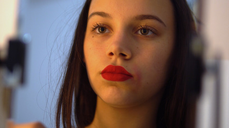 Young beautiful female applying her make-upの写真素材