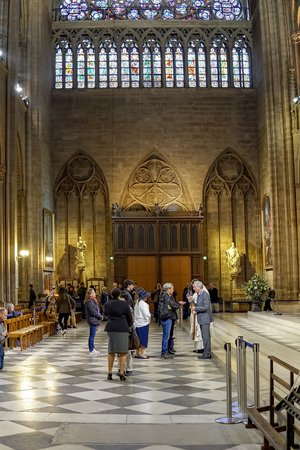 Interior of famous Notre Dame Cathedral with people in religious communion rithual. Notre Dame is 130 meters long, 48 meters wide, 35 meters high, verticalのeditorial素材