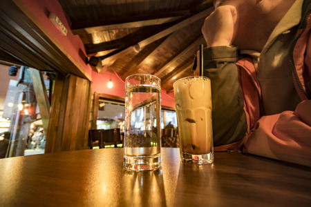 Glass of caffee and water on table in pubの写真素材