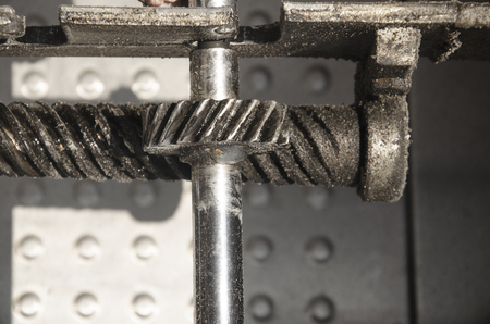 Old gear or cogwheel mechanism to transfer movement from horozontal to vertical axix. Movement transmission. Concept of teamworkの写真素材