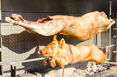 Roasted pig and lamb on the rack in restaurantの写真素材
