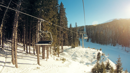 Mountains landscape pov with ski slopes and ski lifts on sunny day at mountain summit Todorka in Bansko ski resort in Bulgariaの写真素材