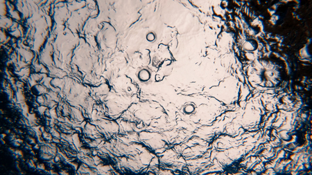 Rain drops in the pool water, underwater view