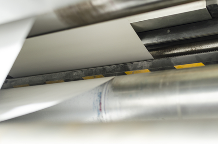 Closeup of printng machine working with roll paper for magazine production