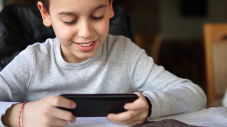 Boy playing games on smartphonesの写真素材