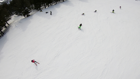 Aerial view from ski lift to ski piste and skiers going fast down the pisteの写真素材