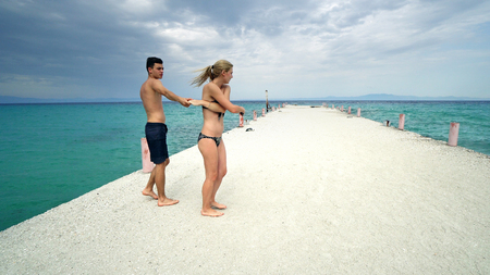 Happy romantic couple dance on beach pier smilingの写真素材