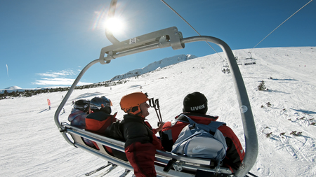 Bansko, Bulgaria - circa Feb, 2018: Skiers and snowboarders at open air ski lift going to the top of the mountain summit for alpine skiingのeditorial素材