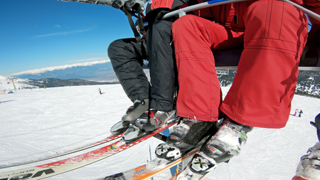 Bansko, Bulgaria - circa Feb, 2018: Skiers and snowboarders at open air ski lift going to the top of the mountain summit for alpine skiingのeditorial素材