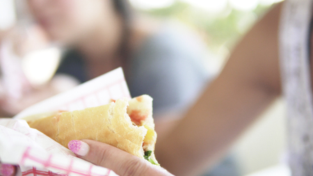 Woman bite into a delicious Shawarma doner sandwichの写真素材