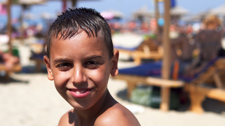 Happy hispanic boy on beach smiling to camera, cinematic dofの写真素材