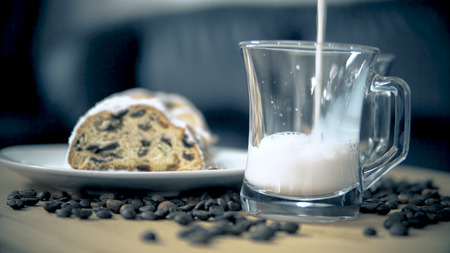 Pouring a cup of white coffee on wooden table with american cookies chocolate cake. Breakfast concept with cinematic dofの写真素材
