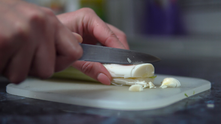 Cooking healthy food. Close up of woman`s hands chopping leekの写真素材