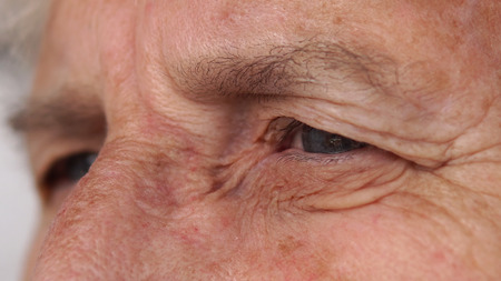 Closeup of lovely elderly woman grandmother eye looking out and blinkの写真素材