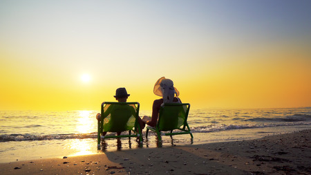 Happy family mother and son with hats enjoy luxury sunset on the beach during summer vacation. Travel conceptの写真素材