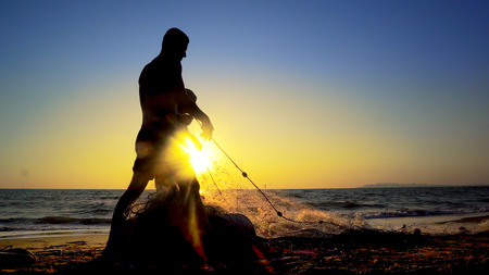 Silhouette Fishermen using fishing nets, fishing with nets in the morning sunrise, cinematicの写真素材