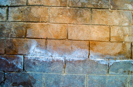 Fragment of old dirty brick wall with peeling plaster texture white grey brown black green blue lime yellow orange maroon violet pink turquoise, stone surface with cracks, useful as background tonedの写真素材