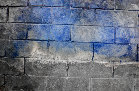 Fragment of old dirty brick wall with peeling plaster texture white grey brown black green blue lime yellow orange maroon violet pink turquoise, stone surface with cracks, useful as background tonedの写真素材