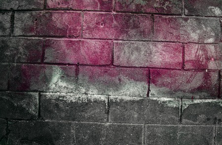 Fragment of old dirty brick wall with peeling plaster texture white grey brown black green blue lime yellow orange maroon violet pink turquoise, stone surface with cracks, useful as background tonedの写真素材