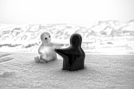 Love melts the ice Valentine `s day concept. F girl and a boy dolls hugs each other, standing on the white snow with blurred background. Hugging sculptures. Souvenir. Marble object. Love. Sympathyの写真素材