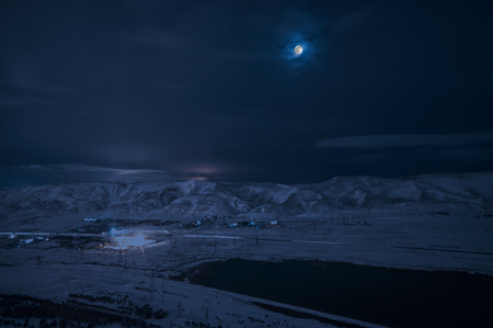 Landscape of snowy mountains and lake with full moon above. The moon and clouds on sky. Baku, Azerbaijan, Xojasan Lakeの写真素材