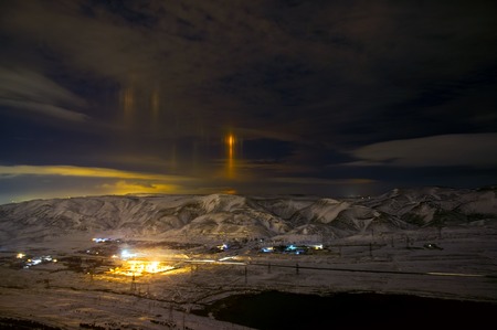 Night snow mountain landscape with straingh yellow light to the sky. Mystical concept. Baku, Azerbaijanの写真素材