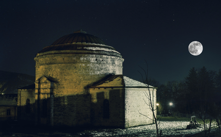 View of building in the night and with tree nearby under dark sky with rising Moonの写真素材