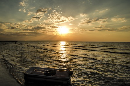 Silhouette of a man on an inflatable mattress swimming in the water of Caspian Sea at sunset time. Summertime in Azerbaijan, Absheron, Bakuの写真素材