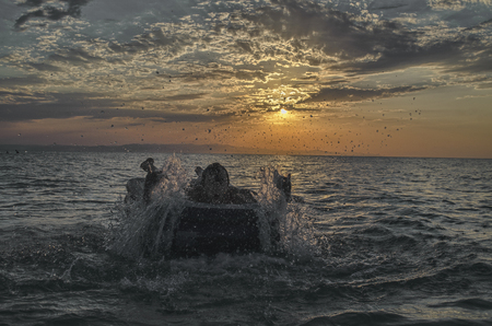 Silhouette of a man on an inflatable mattress swimming in the water of Caspian Sea at sunset time. Summertime in Azerbaijan, Absheron, Bakuの写真素材