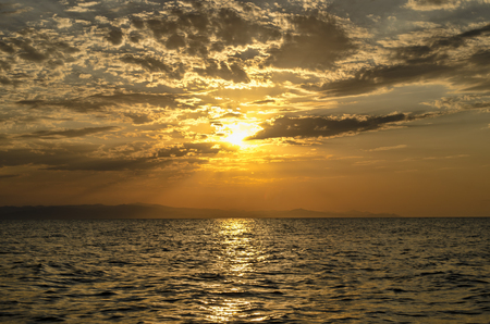 Beautiful blazing sunset landscape at Caspian sea and orange sky above it with awesome sun golden reflection on calm waves as a background. Amazing sunset view on the beach. Azerbaijan Absheron, Bakuの写真素材