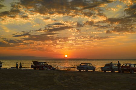 Beautiful blazing sunset landscape at Caspian sea and orange sky above it with awesome sun golden reflection on calm waves as a background. Amazing sunset view on the beach. Azerbaijan Absheron, Bakuの写真素材